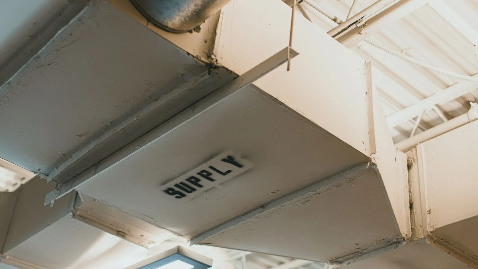 Sheet metal air distribution ductwork running along a ceiling