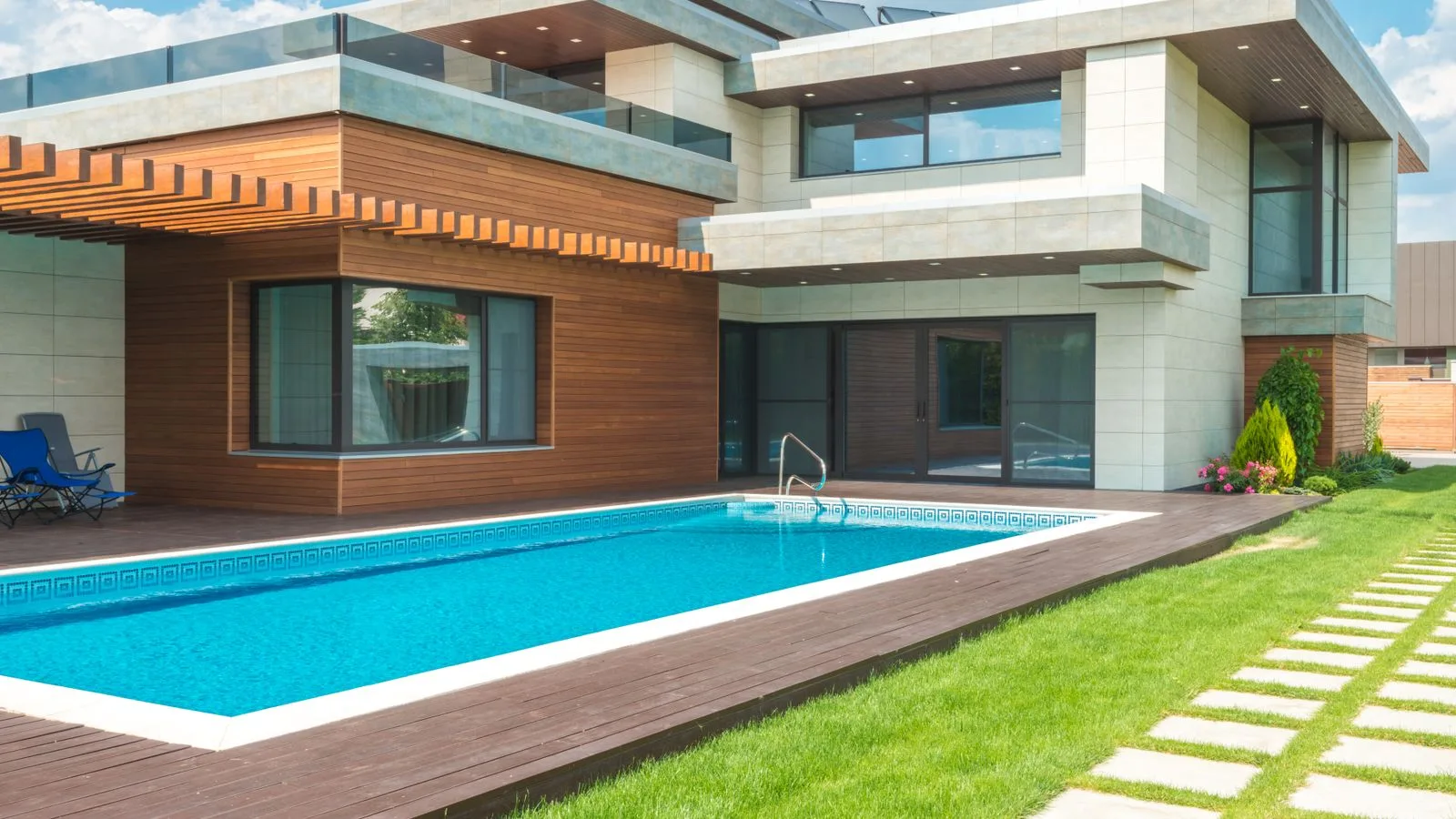 Modern home with a backyard swimming pool and landscaped lawn